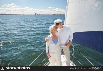 sailing, age, tourism, travel and people concept - happy senior couple kissing on sail boat or yacht deck floating in sea