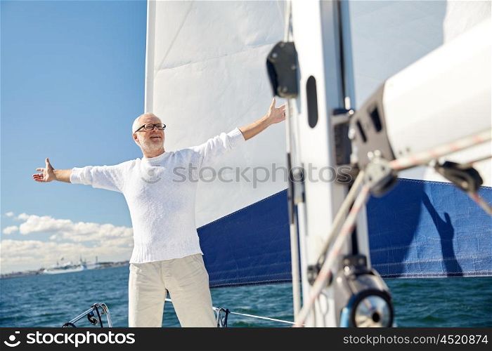 sailing, age, tourism, travel and people concept - happy senior man enjoying freedom on sail boat or yacht floating in sea