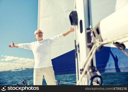 sailing, age, tourism, travel and people concept - happy senior man enjoying freedom on sail boat or yacht floating in sea