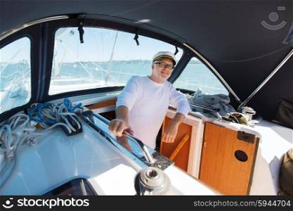 sailing, age, tourism, travel and people concept - happy senior man in captain hat on sail boat or yacht floating in sea