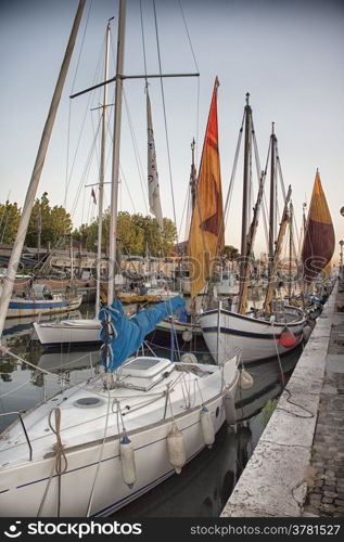 Sailing and engine boats moored in the harbour channel of Cervia in Northern Italy on the Adriatic Sea