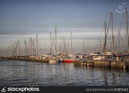 Sailing and engine boats moored in the harbour channel of Cervia in Northern Italy on the Adriatic Sea