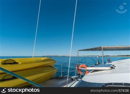 Sailing boat and stand up paddle boards. Wide angle view in the sea