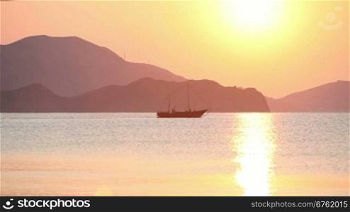 Sailing boat in the sea at sunrise