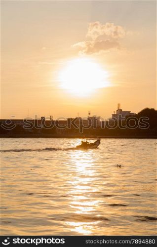 Sailing boat on the river. The sun is about to fall. Sunlight reflecting off the river