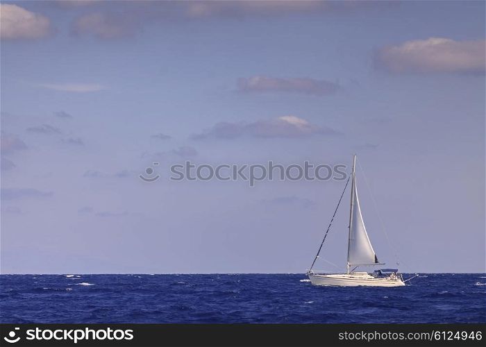 Sailing boat with mainsail in open blue sea&#xA;
