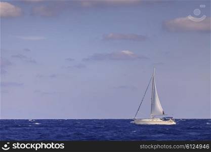 Sailing boat with mainsail in open blue sea&#xA;