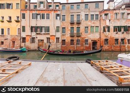 Sailing gondola in Venice near pier in channel&#xA;