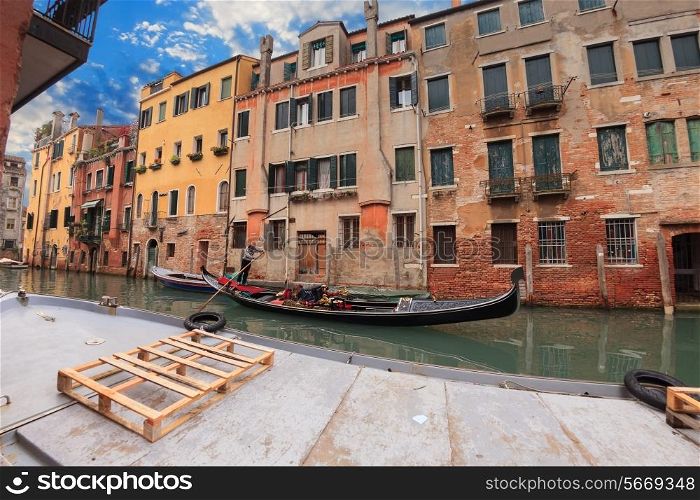 Sailing gondola in Venice near pier in channel&#xA;