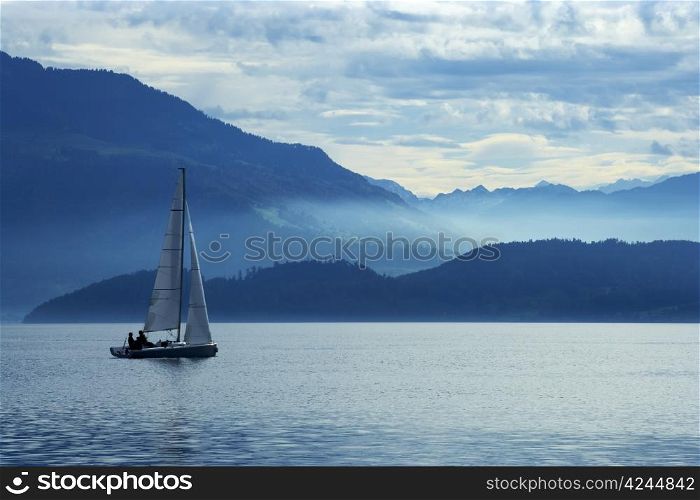 Sailing on Lake Zug in Switzerland with the Alps in the background.