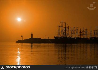 Sailing ships against the backdrop of the setting sun.
