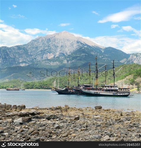 Sailing ships in the bay against background mountains