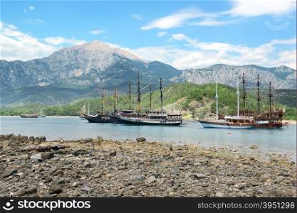 Sailing ships in the bay against background mountains
