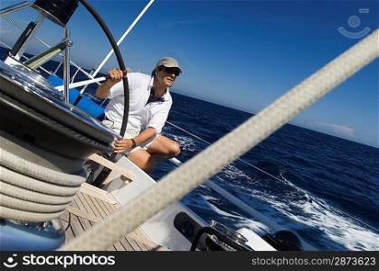 Sailor at the Helm During Sailing Yacht Race