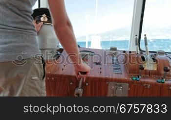 sailor controls boat in the wheelhouse