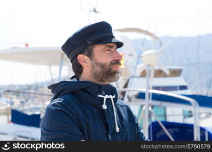 Sailor man in marina port with boats background and blue cap