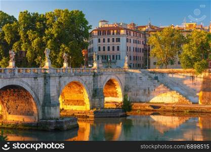 Saint Angel bridge at sunrise, Rome, Italy.. Saint Angel bridge with mirror reflection in Tiber River at sunset in Rome, Italy.