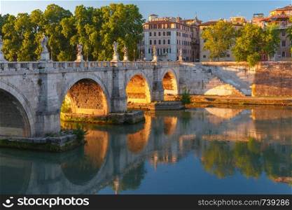 Saint Angel bridge with mirror reflection in Tiber River at sunset in Rome, Italy.. Saint Angel bridge at sunrise, Rome, Italy.