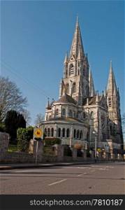 Saint Fin Barre&rsquo;s cathedral in Cork, Ireland (road view and blue sky background)