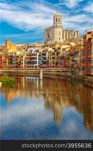 Saint Mary Cathedral, colorful yellow and orange houses and famous white house Casa Maso reflected in water river Onyar, in Girona, Catalonia, Spain.