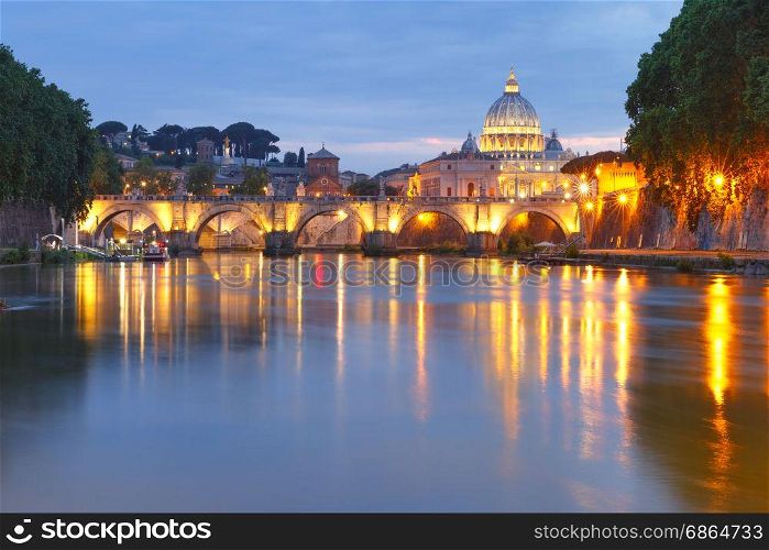 Saint Peter Cathedral at night in Rome, Italy.. Saint Angel bridge and Saint Peter Cathedral with a mirror reflection in the Tiber River during evening blue hour in Rome, Italy.