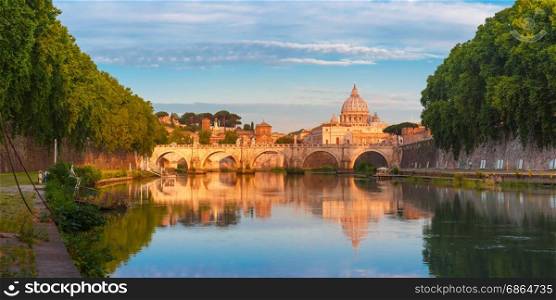 Saint Peter Cathedral in the morning, Rome, Italy.. Panorama of Saint Angel bridge and Saint Peter Cathedral with a mirror reflection in the Tiber River in the sunny morning in Rome, Italy.
