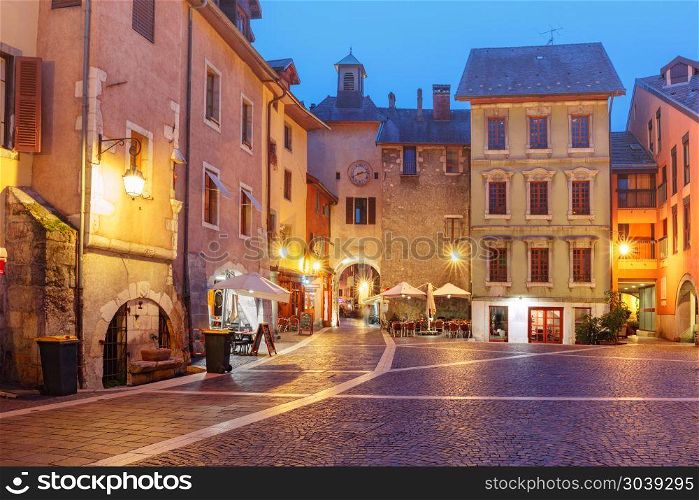 Sainte-Claire gate in Old Town of Annecy, France. Sainte-Claire gate with clock tower and Place Sainte-Claire in Old Town at rainy night, Annecy, France