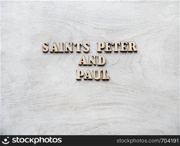 Saints Peter and Paul. Wooden, unpainted letters on a white table. Close-up, top view. Beautiful photo. Congratulations for loved ones, family, relatives, friends and colleagues. Saints Peter and Paul. Wooden, unpainted letters