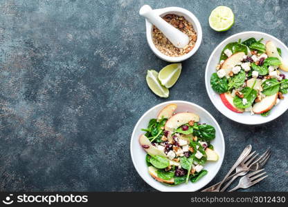 salad bowl of spinach, apple, soft cheese, nuts and cranberry. top view, healthy diet eating, superfood