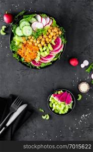 Salad Buddha bowl with fresh cucumber, celery, watermelon radish, raw carrot, lettuce, radish and chickpea for lunch. Healthy vegetarian food. Vegan vegetable dish. Top view