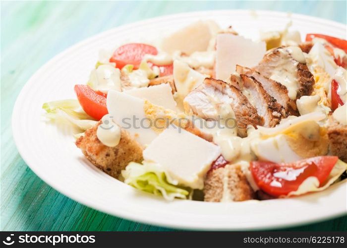 Salad Caesar in a white plate on the table. Salad Caesar in a plate