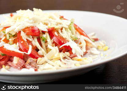 Salad from beef tongue, cervelat, chicken meat, fresh tomatoes, cucumbers, pepper, eggs, cheese and mayonnaise