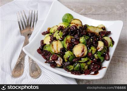 Salad from Brussels sprouts with dried cranberries under balsamic sauce
