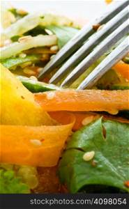 Salad from fresh vegetables with the fork close up