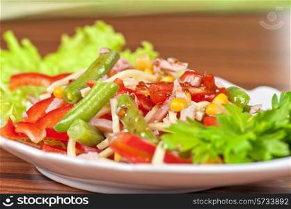 Salad from ham, tomato, green beans, corn and greens