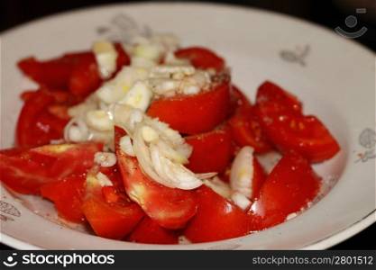 Salad from sliced red tomatoes under onion