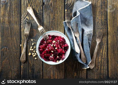 Salad of boiled beet. Beetroot salad with picled cucumber, nuts, eggs and oil in a bowl