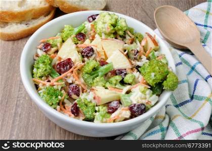 Salad of broccoli, carrots, apples, rice, cranberries and walnuts dressed with yogurt