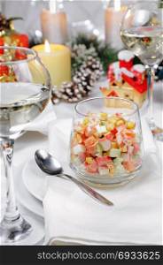 Salad of cubes of crab meat and vegetables dressed with yogurt in a glass on the Christmas table