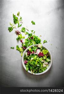 salad of fresh greens. On the metal table.. salad of fresh greens.