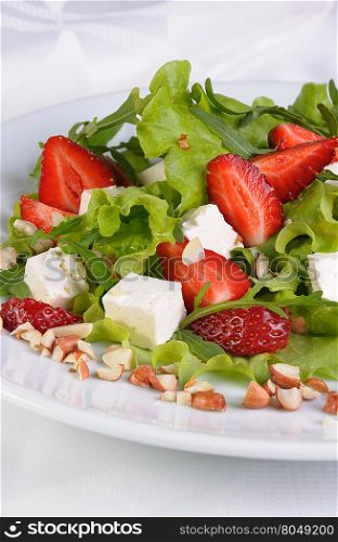 Salad of lettuce, arugula, strawberries, feta cheese and peanuts