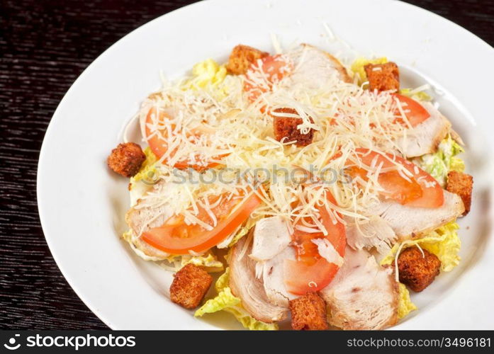 Salad of lettuce, chinese cabbage, tomato, garlic rusk, parmesan cheese, sauce and chicken meat