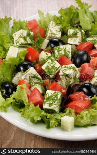 Salad of lettuce with diced olives, tomato, cucumber, feta at dill