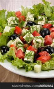 Salad of lettuce with diced olives, tomato, cucumber, feta at dill