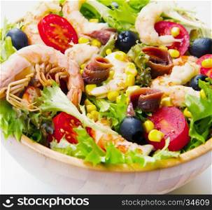 salad of shrimp, mixed greens, black olives anchovies and tomatoes isolated on white