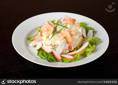 Salad of shrimps, crab meat, cucumbers, apples, potatoes, lettuce, maize, eggs and mayonnaise