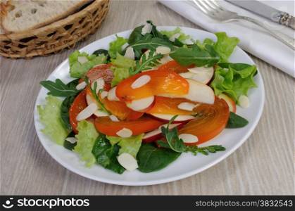 salad of spinach, arugula, lettuce, persimmon, apple and almonds