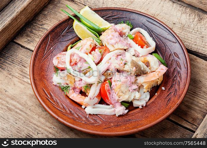 Salad of squid, fish and shrimp on a plate.Homemade seafood salad. Delicious spicy seafood salad
