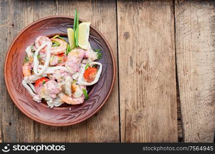 Salad of squid, fish and shrimp on a plate.Homemade seafood salad. Appetizing seafood salad.