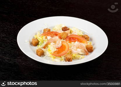 Salad of tiger shrimps, lettuce, chinese cabbage, tomato, garlic rusk, parmesan cheese and sauce